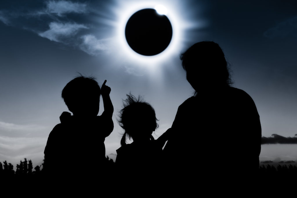Natural phenomenon. Silhouette of family sitting and relaxing together.